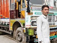 Sandeep Kumar, 24 truck driver outisde his truck.