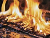 Laptop burning in flames on a desk, fire hazard. losing valuable data, closeup